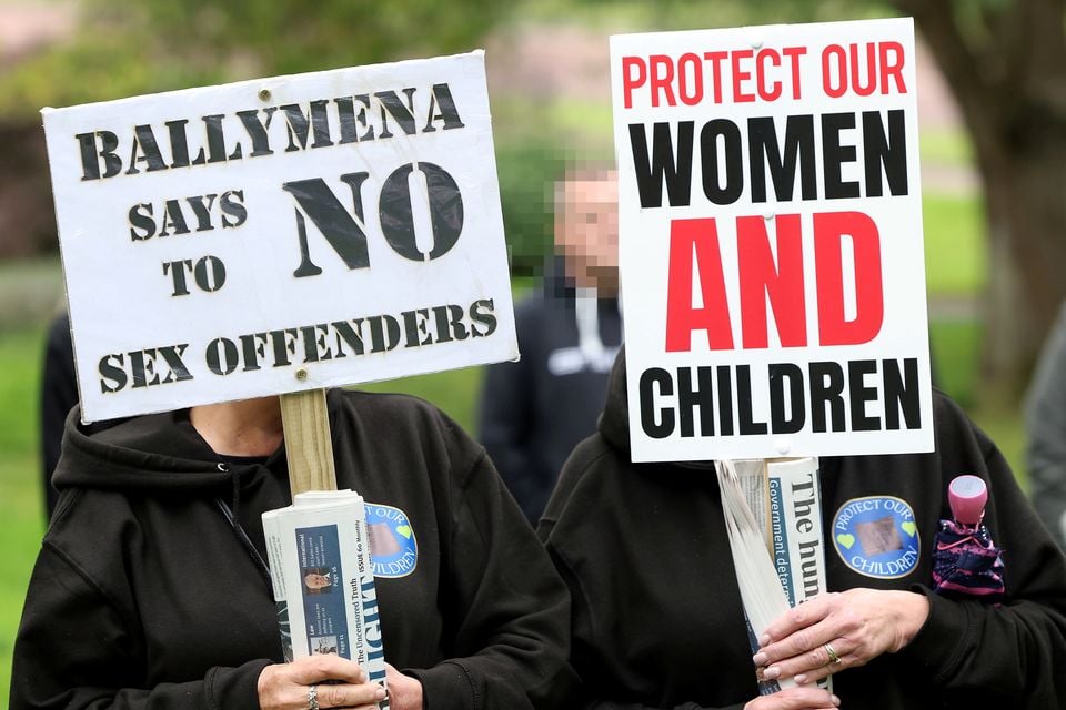 Signs being held at an anti-Immigration protest in Stormont Estate